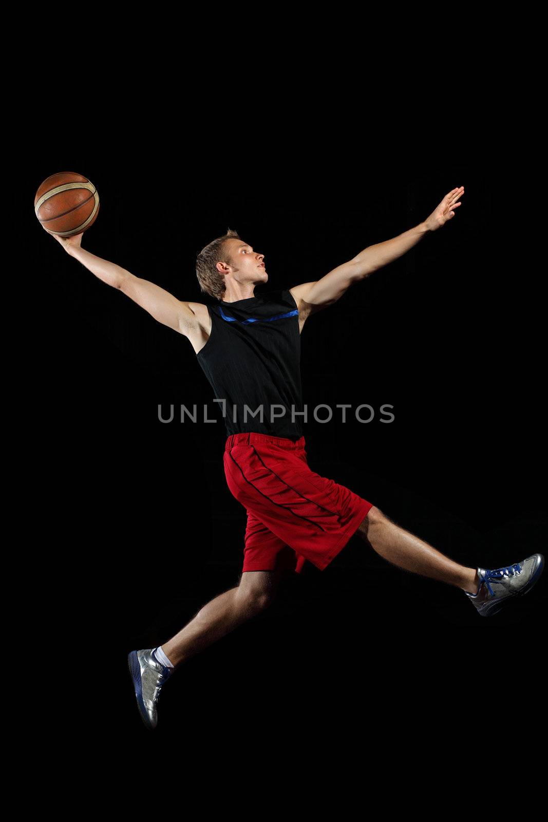 Male basketball player jumping and practicing with a ball