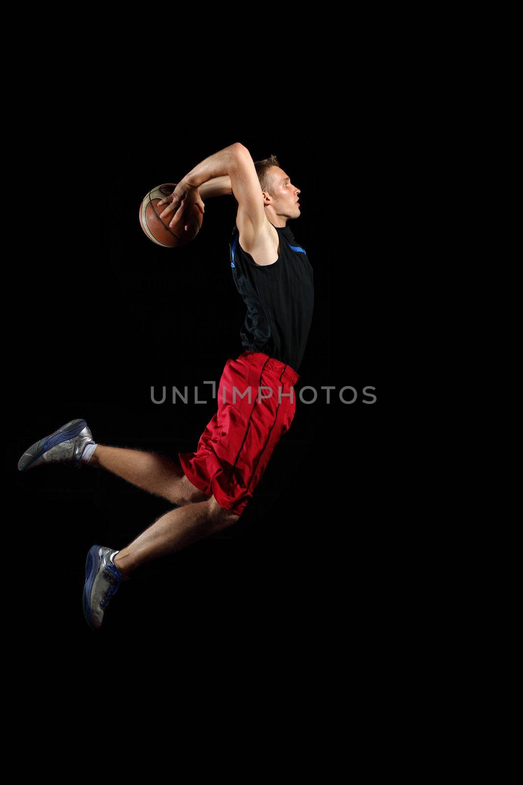 Male basketball player jumping and practicing with a ball