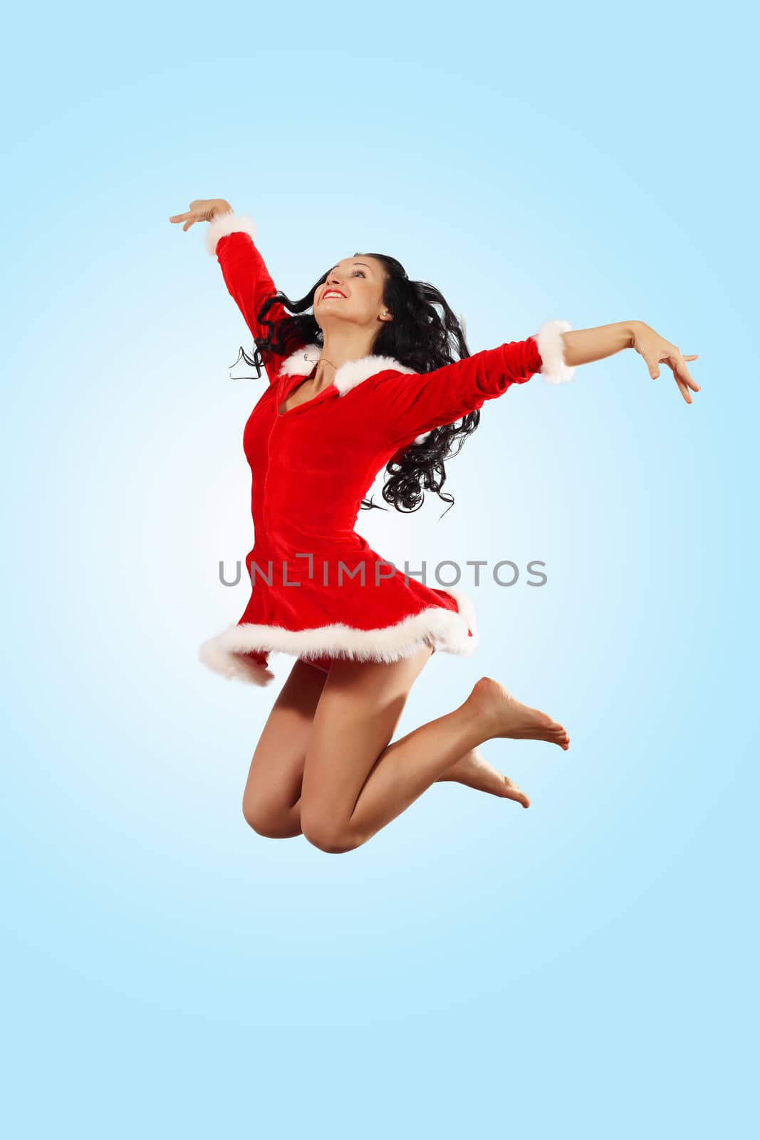 Happy smiling woman in red xmas costume jumping high