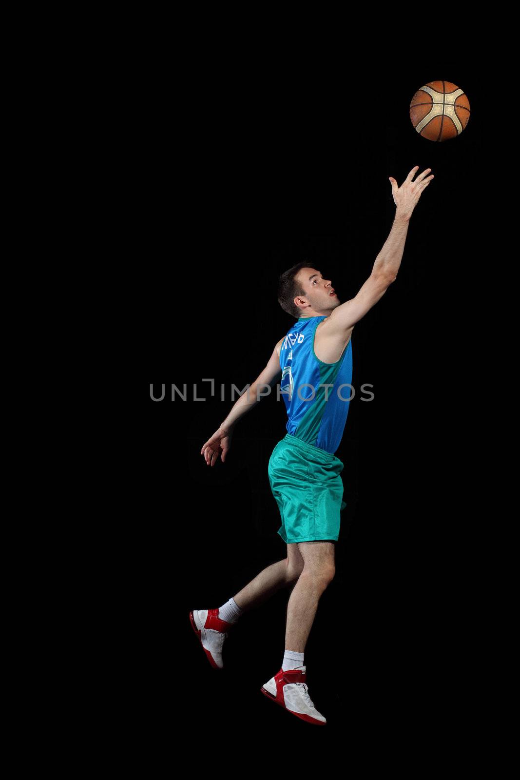 Male basketball player jumping and practicing with a ball