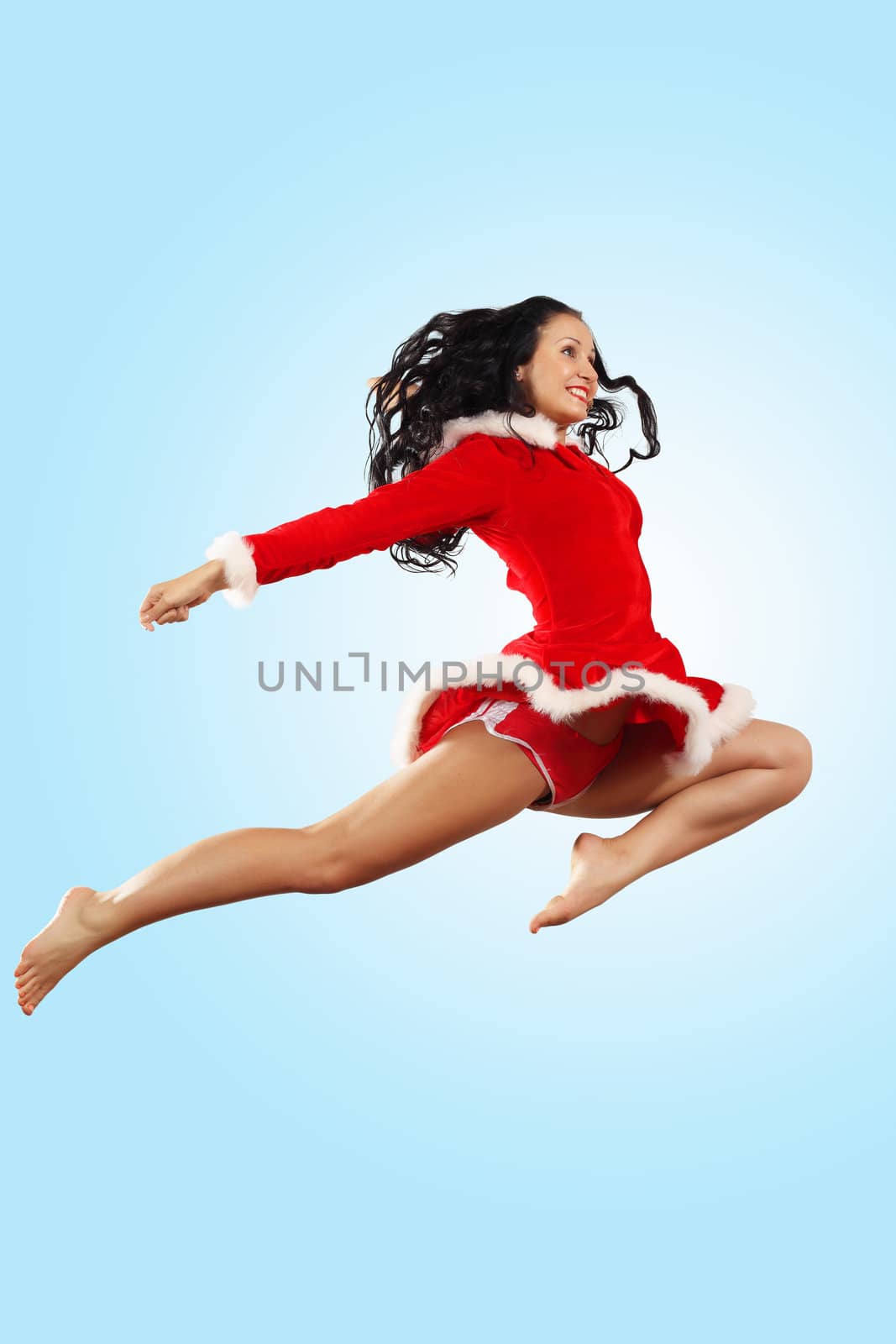 Happy smiling woman in red xmas costume jumping high