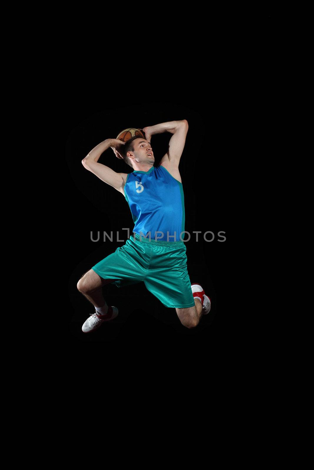 Male basketball player jumping and practicing with a ball