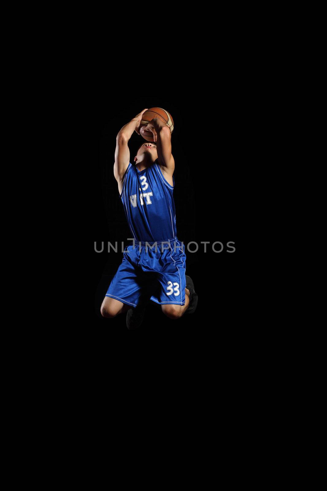 Male basketball player jumping and practicing with a ball