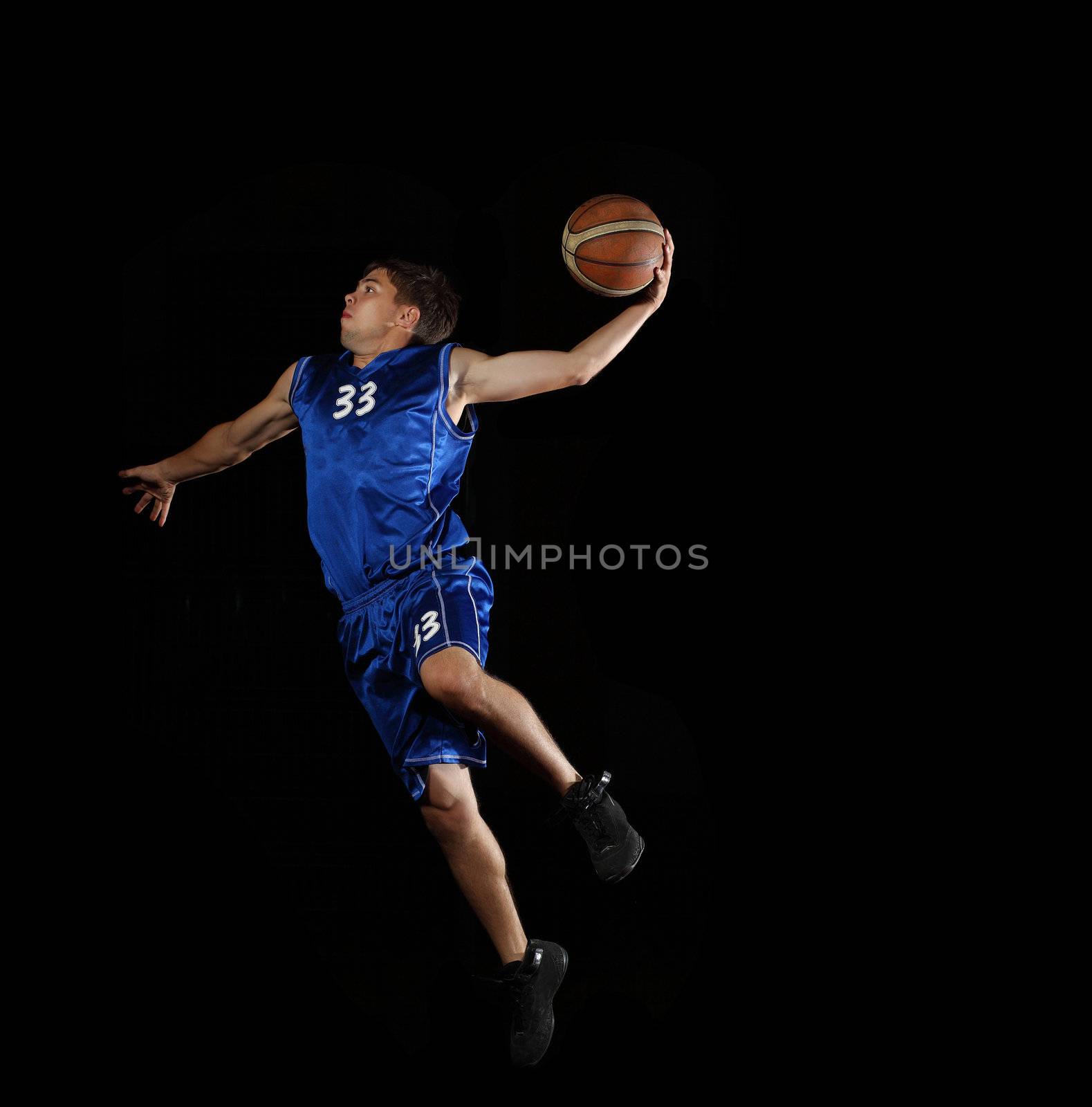 Male basketball player jumping and practicing with a ball