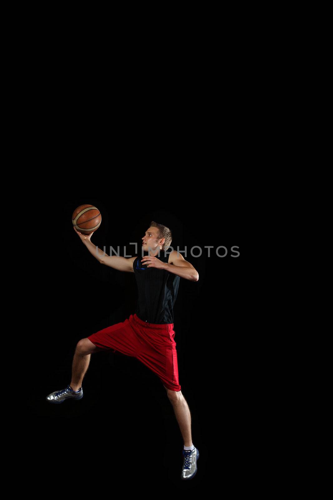 Male basketball player jumping and practicing with a ball