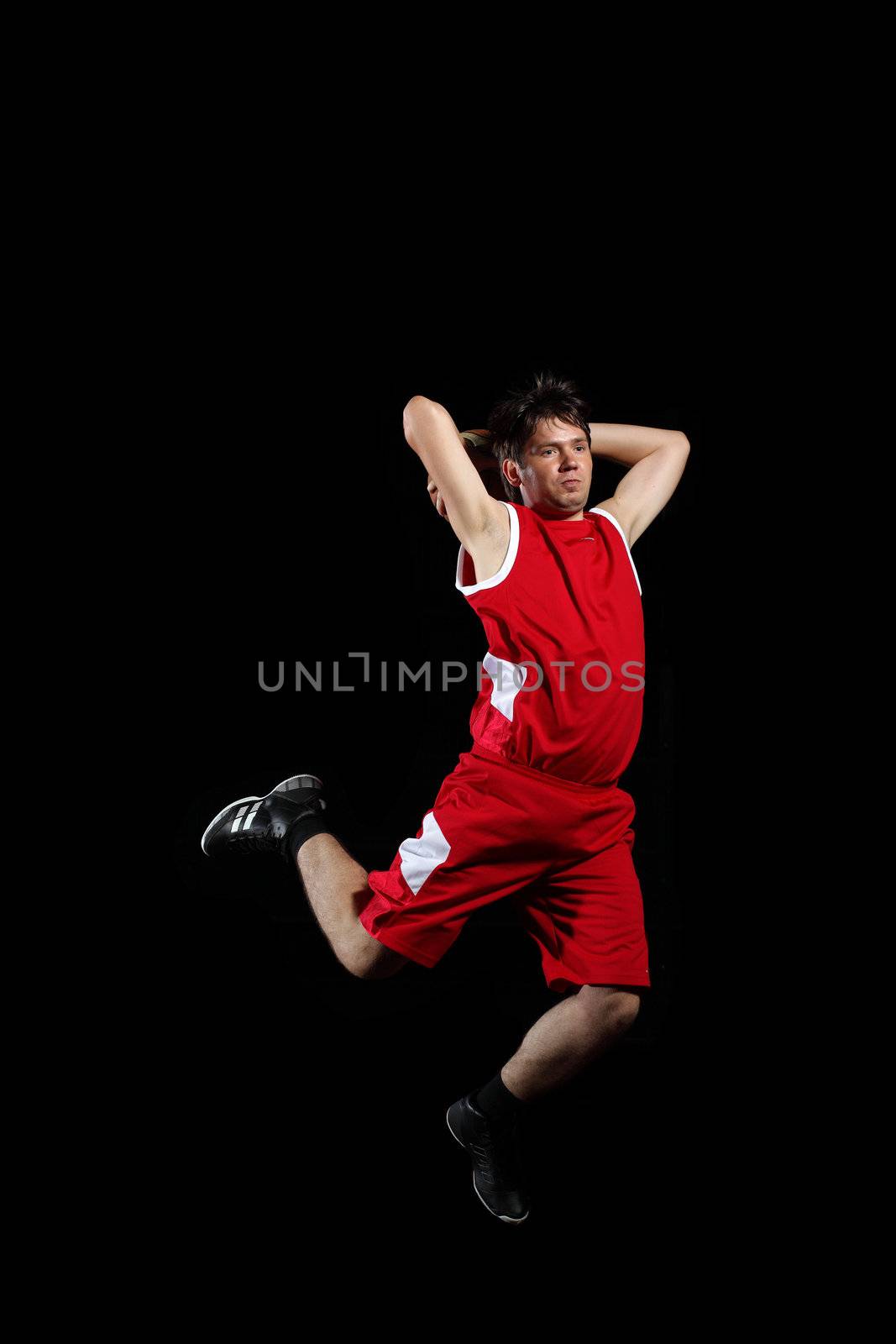 Male basketball player jumping and practicing with a ball