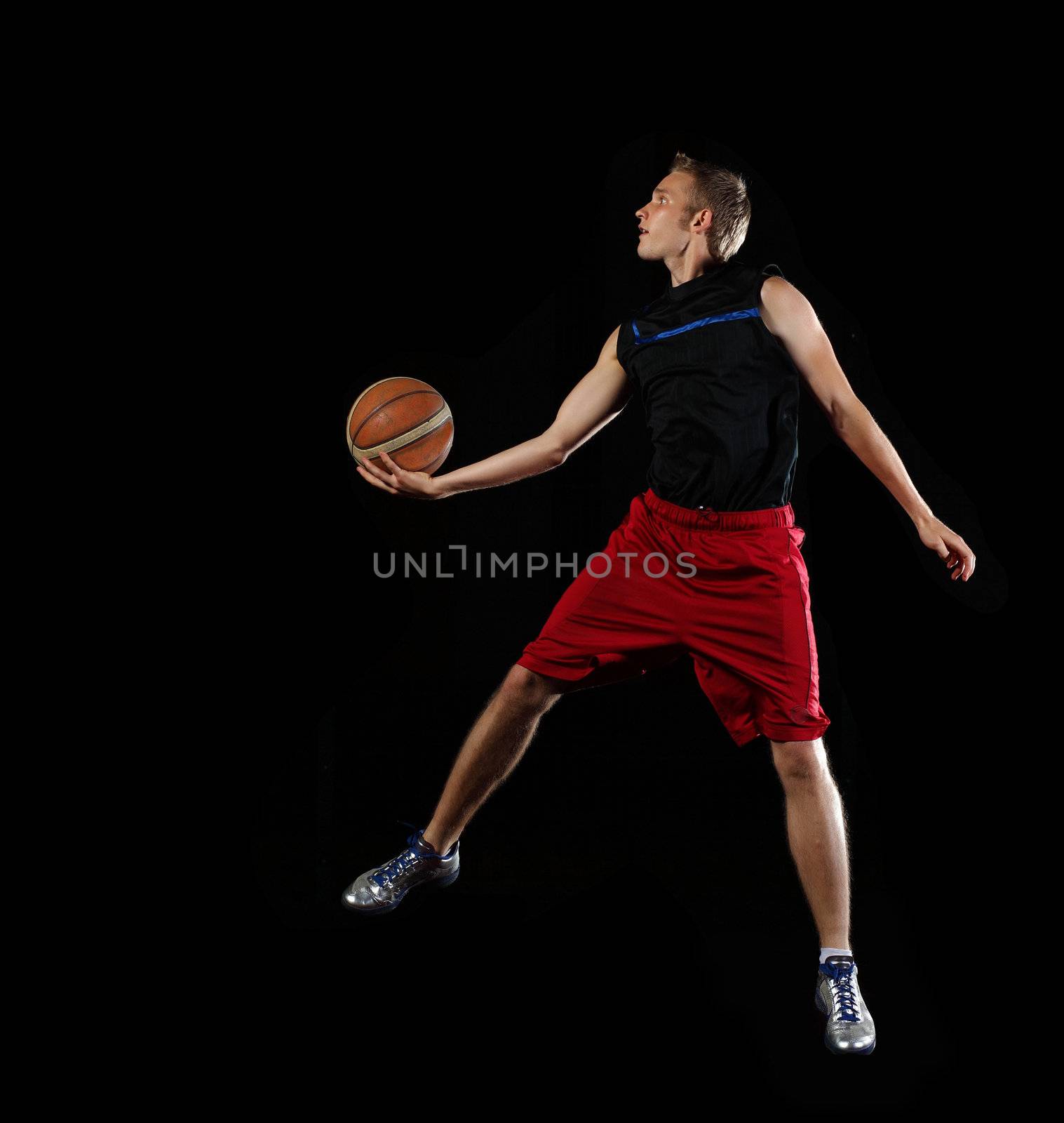 Male basketball player jumping and practicing with a ball