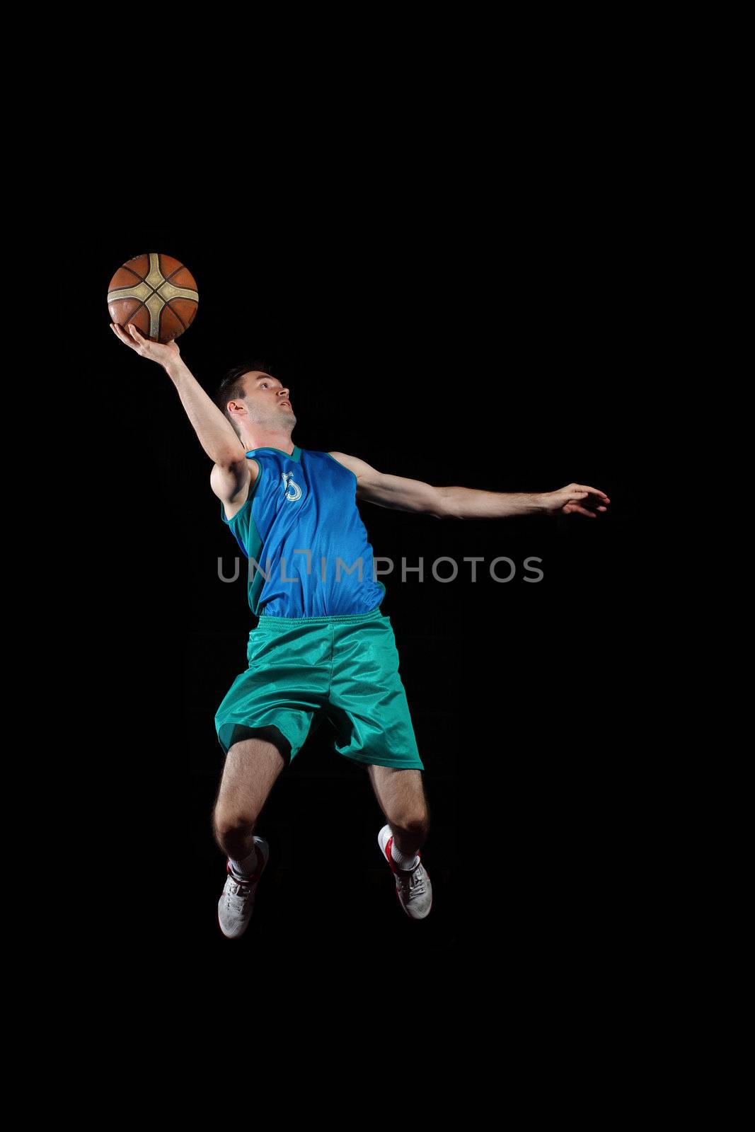 Male basketball player jumping and practicing with a ball