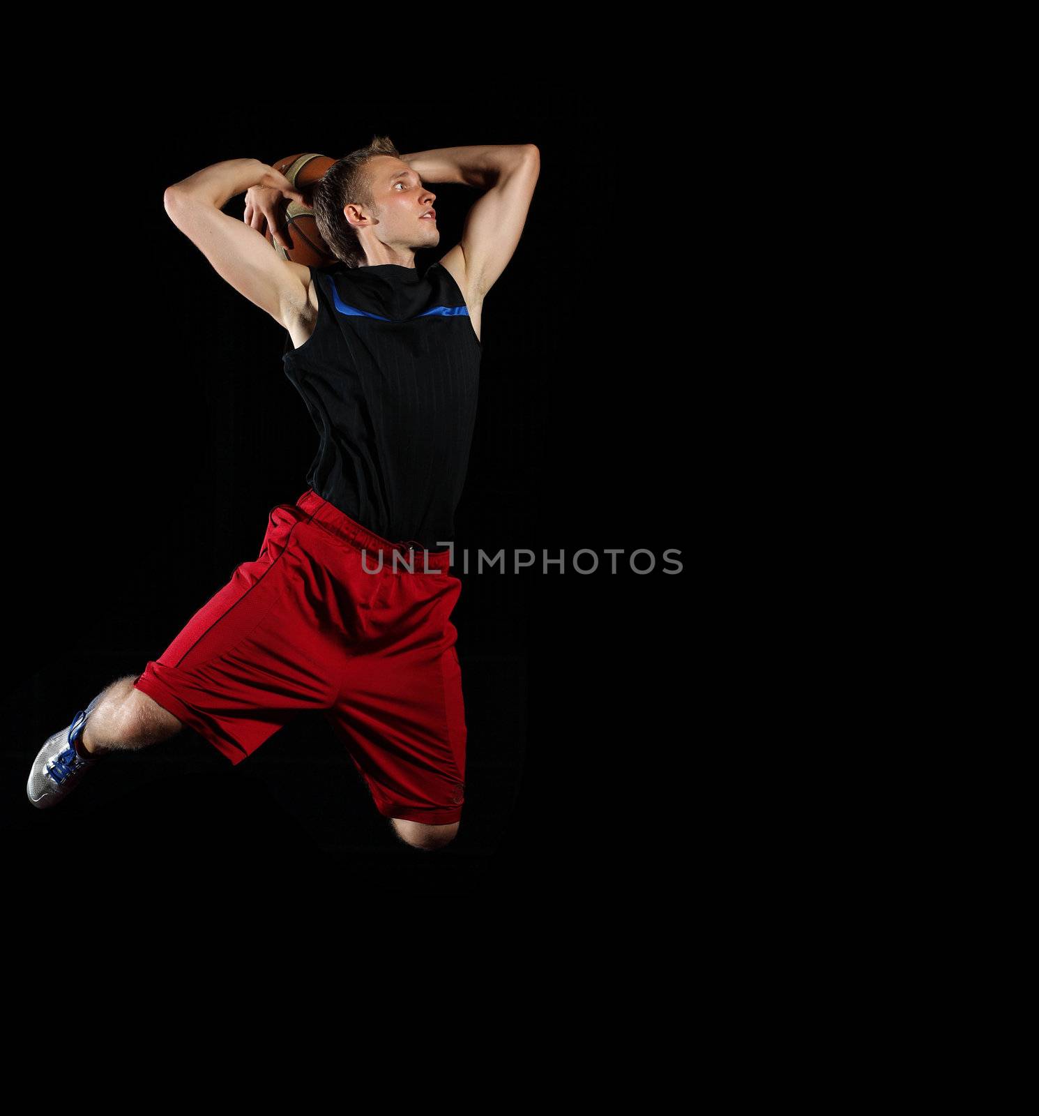 Male basketball player jumping and practicing with a ball