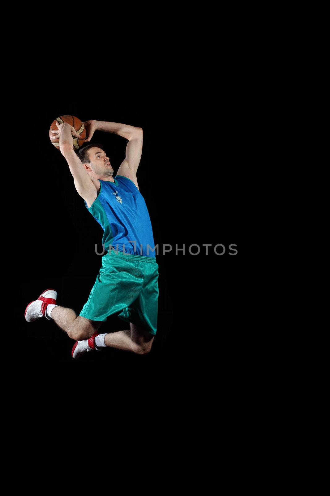 Male basketball player jumping and practicing with a ball