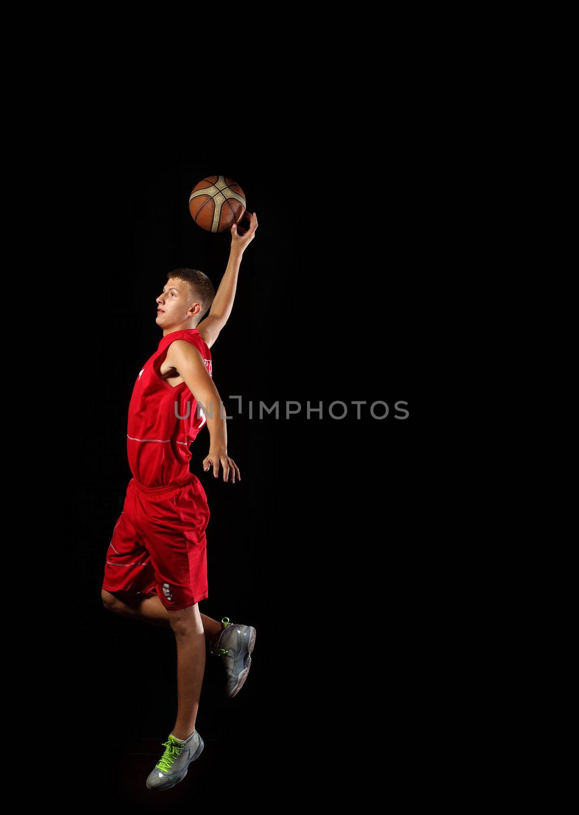 Male basketball player jumping and practicing with a ball