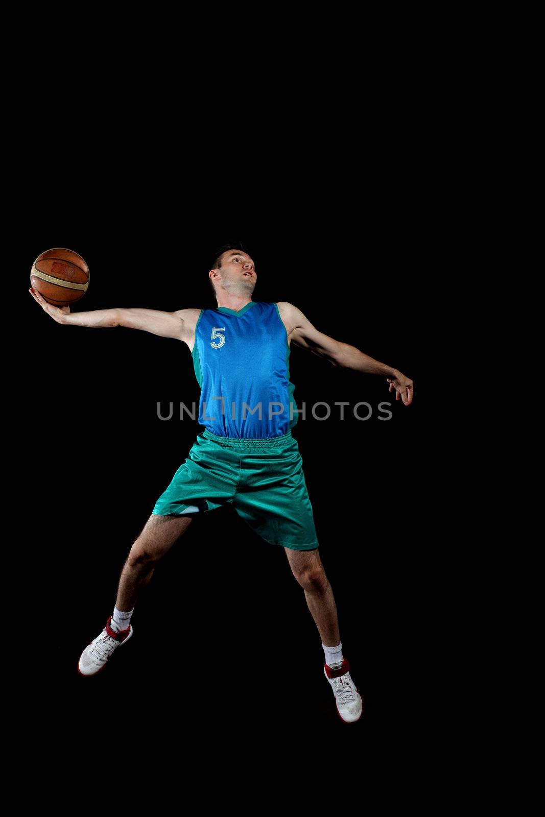 Male basketball player jumping and practicing with a ball