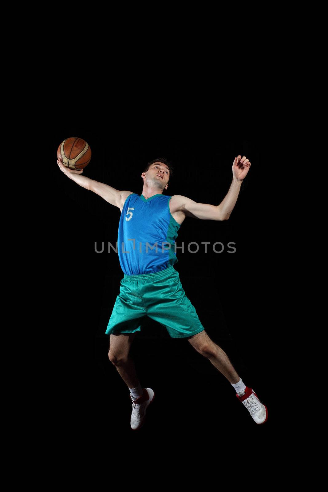 Male basketball player jumping and practicing with a ball