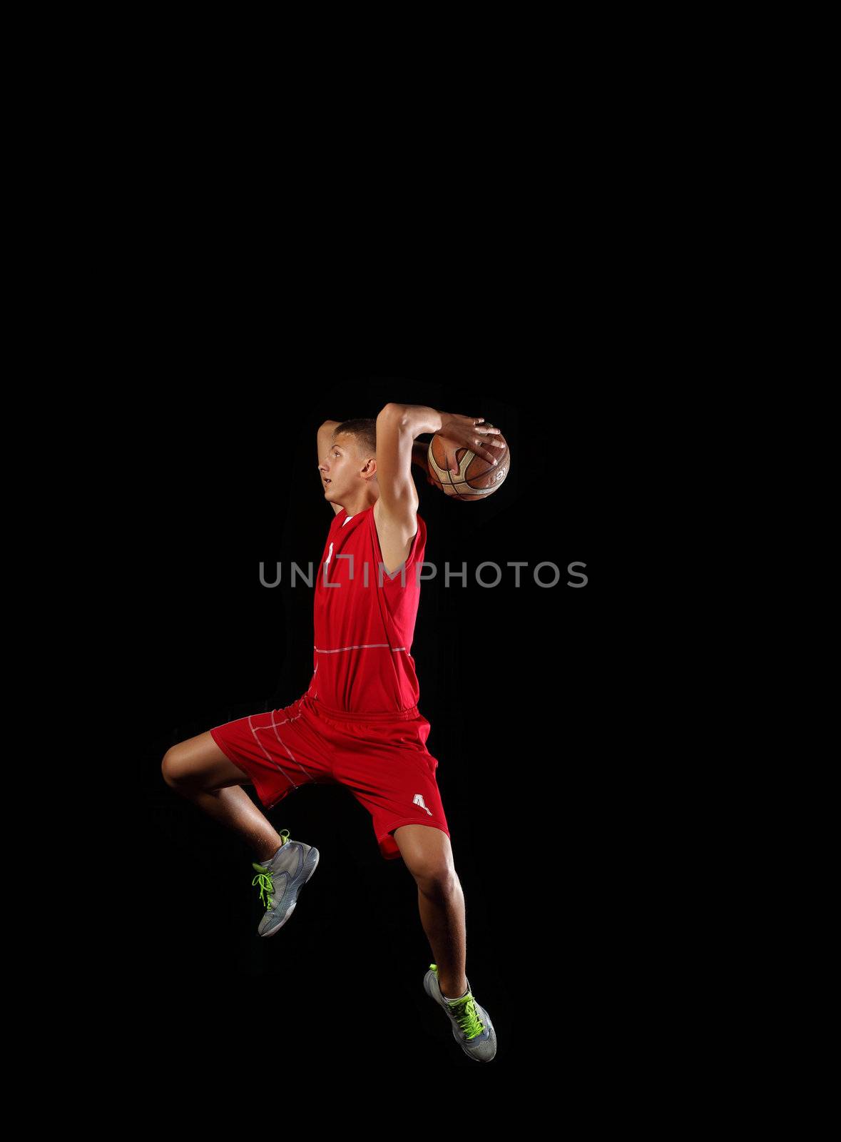 Male basketball player jumping and practicing with a ball