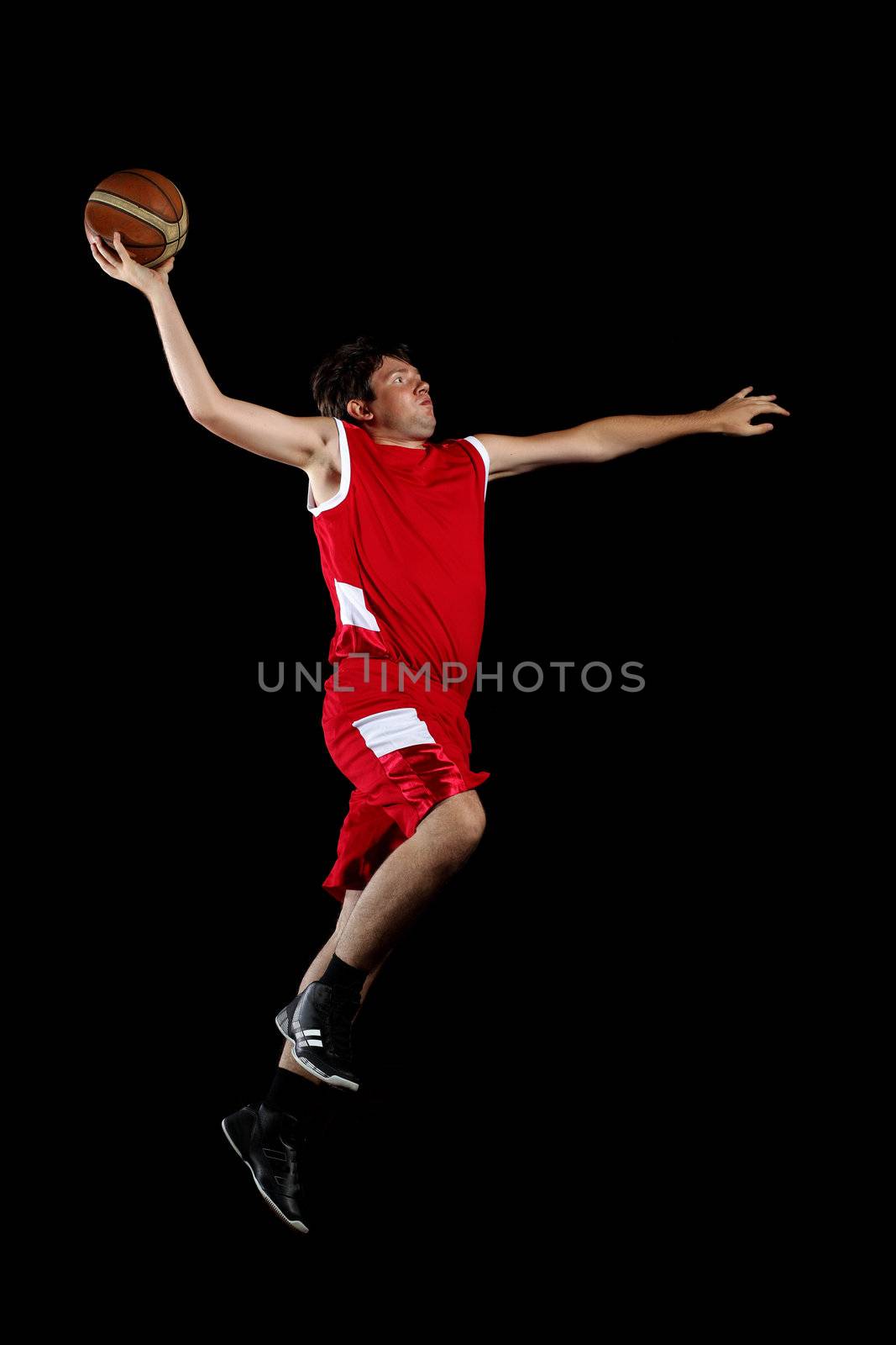 Male basketball player jumping and practicing with a ball