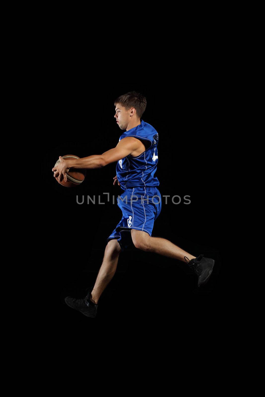 Male basketball player jumping and practicing with a ball