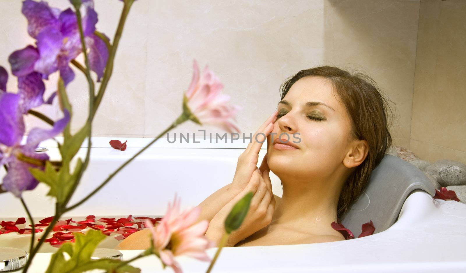 woman in a bath with rose-petals by ssuaphoto