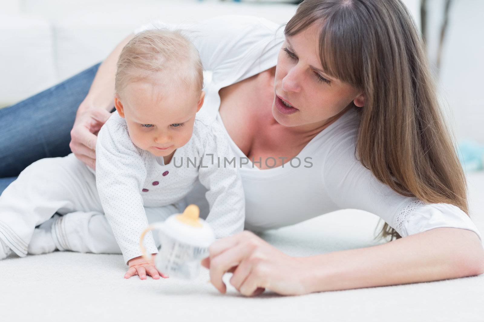 Baby and mother sitting on the floor in living room