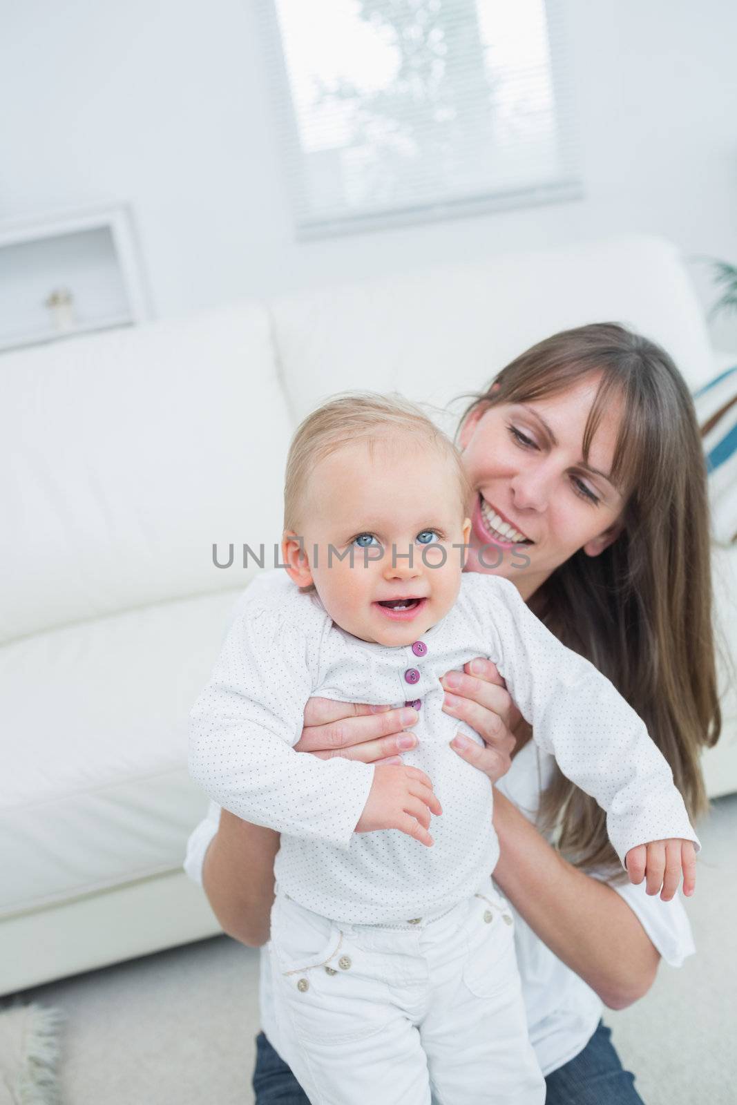 Mother holding a baby in living room