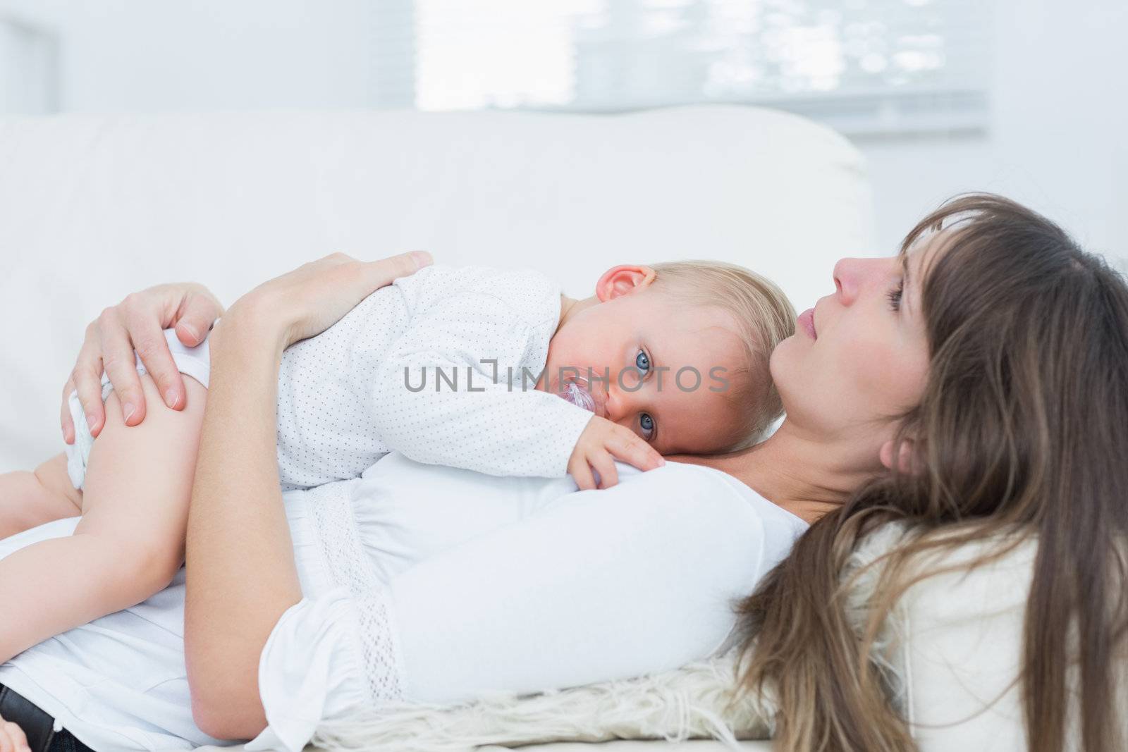 Baby lying on the chest of a mother in living room