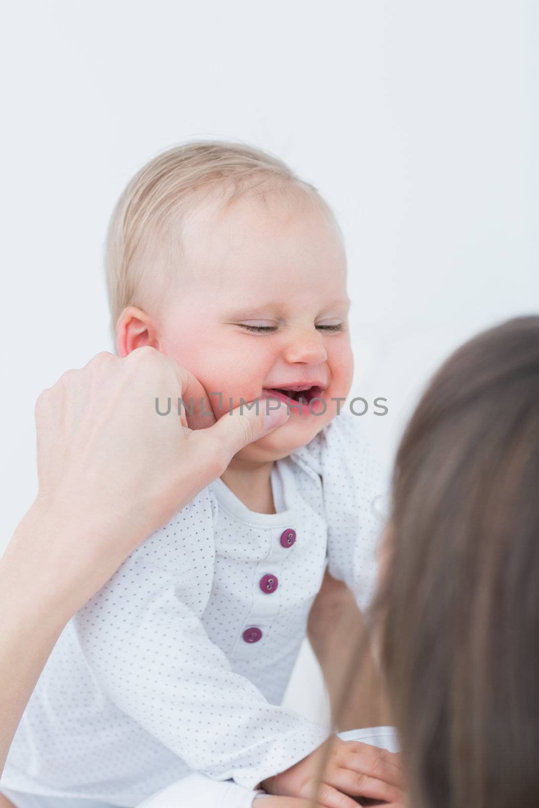 Mother touching the cheek of a baby in living room