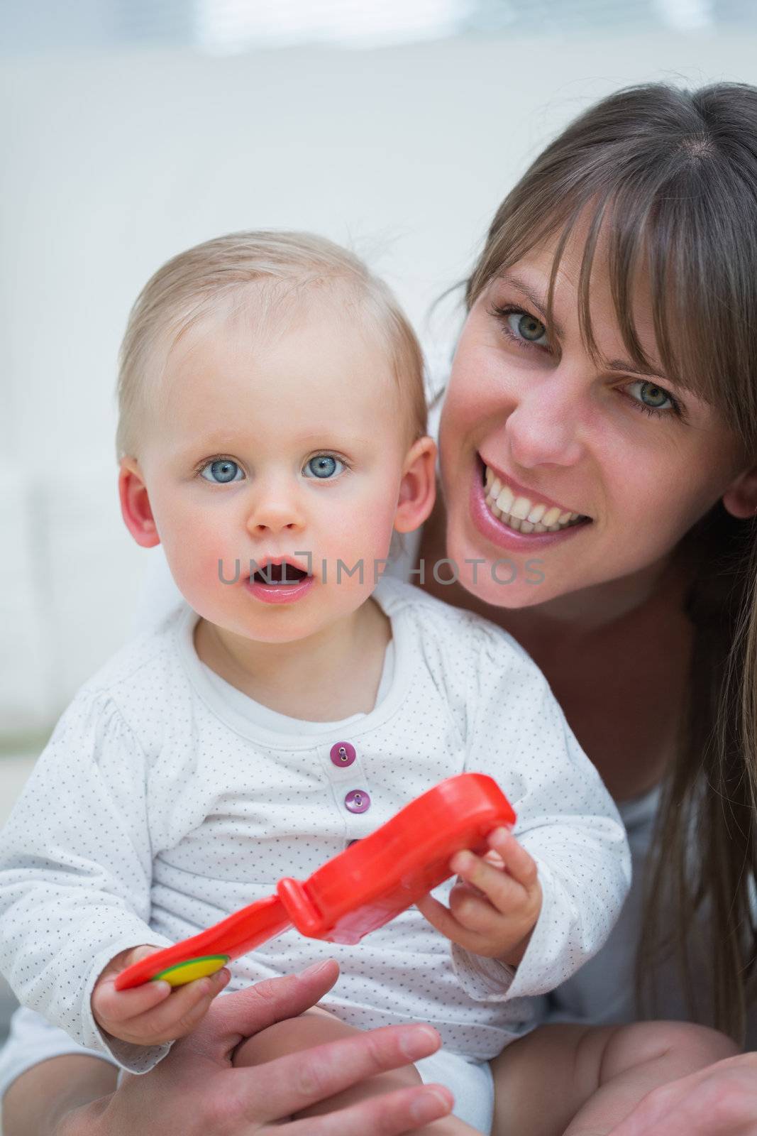 Baby holding a toy by Wavebreakmedia