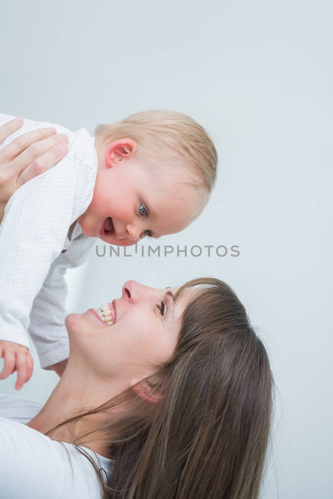 Smiling mother holding her baby in living room