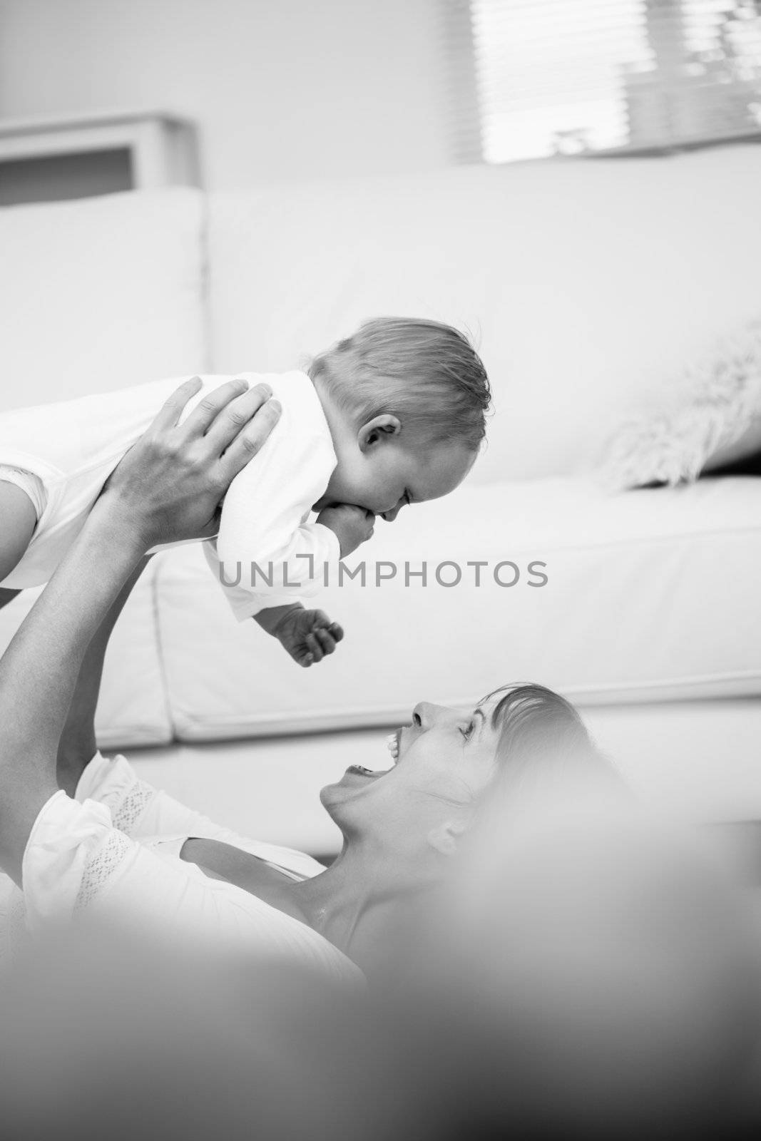 Mother lifting her baby in living room