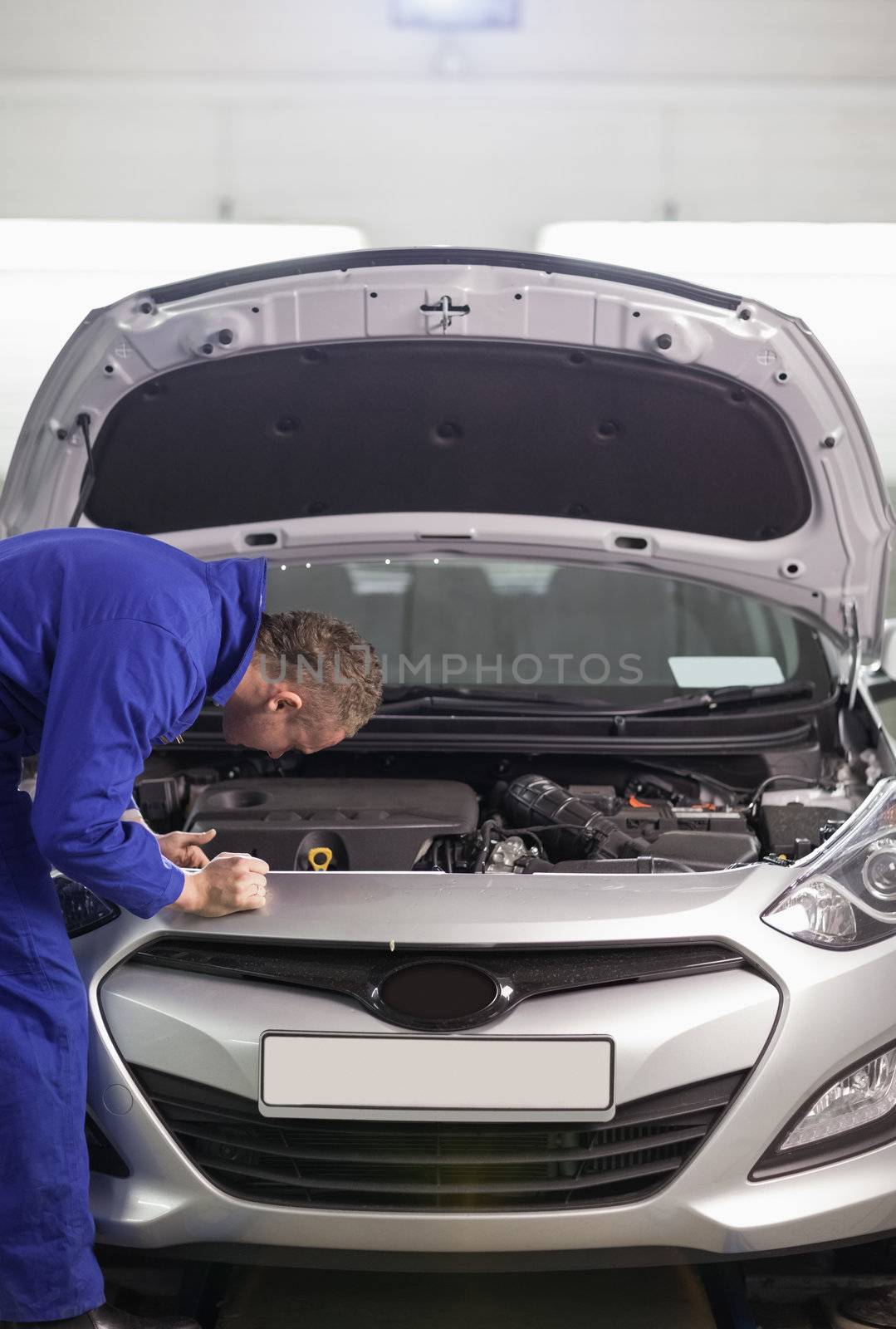 Mechanic leaning on a car in a garage