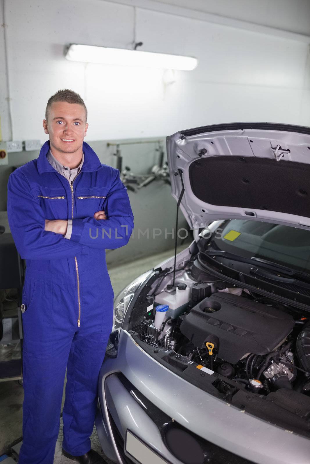 Smiling mechanic standing in a garage
