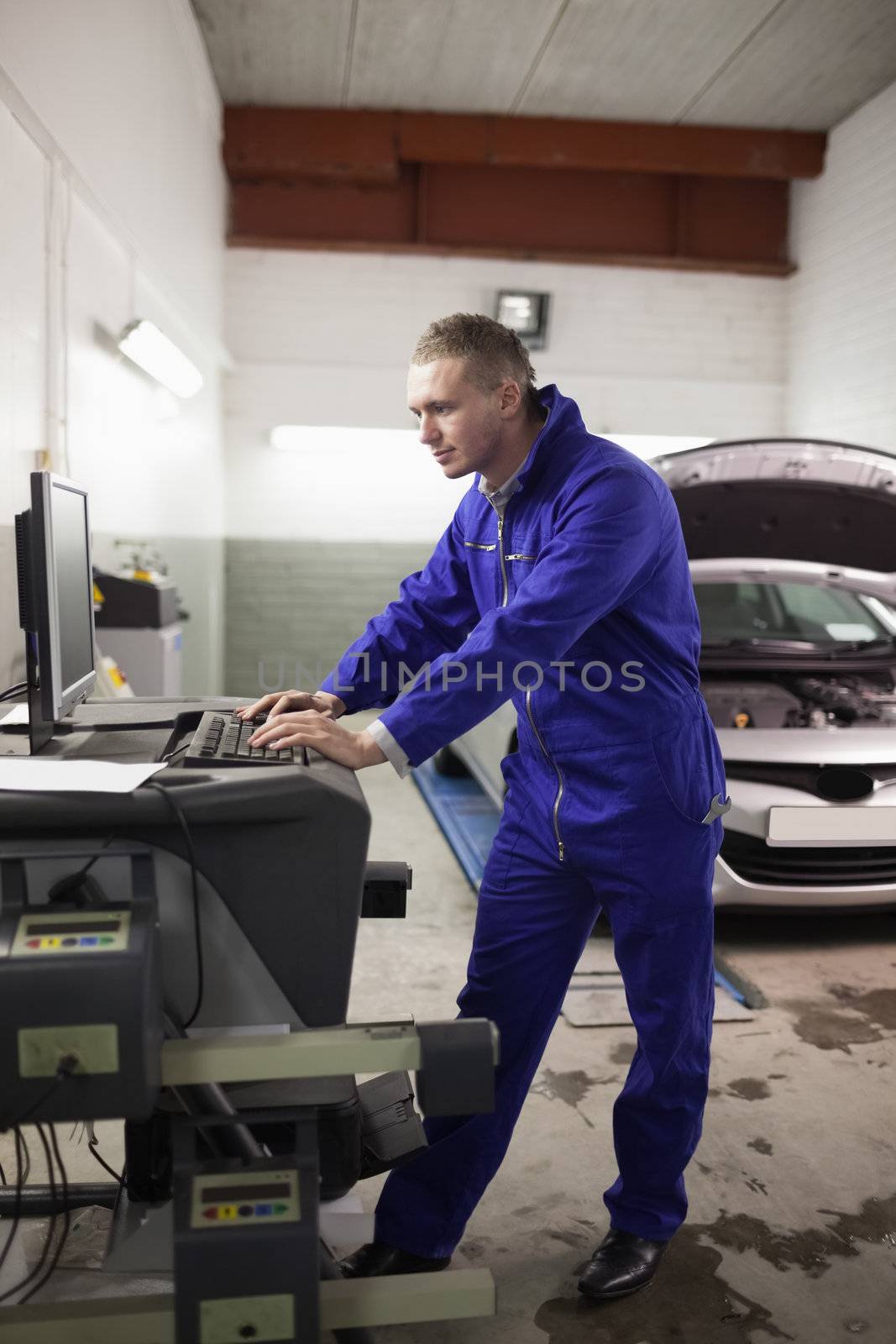 Concentrated mechanic using a computer in a garage