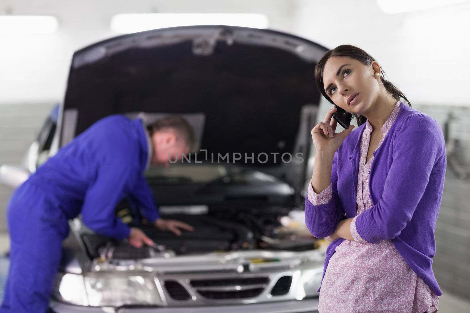 Client calling next to a mechanic in a garage