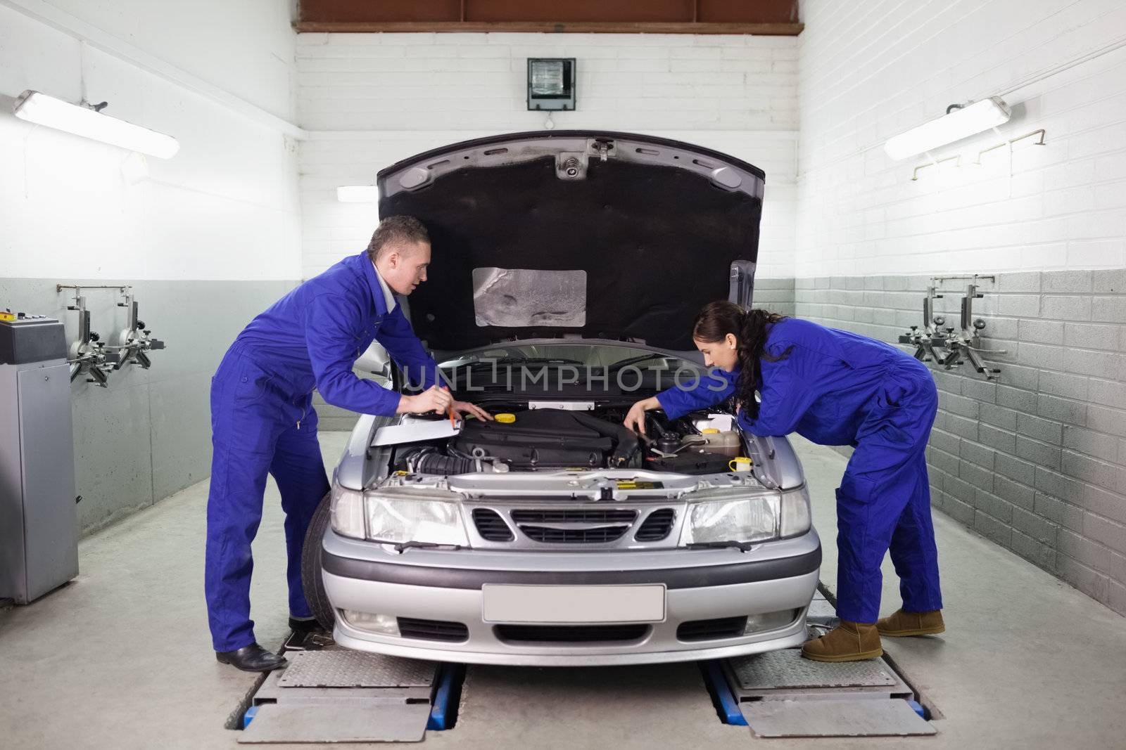 Mechanics looking at the engine in a garage