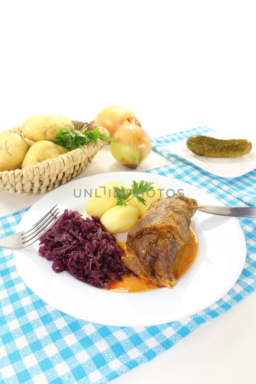 roasted beef roulade with potatoes and red cabbage on a bright background