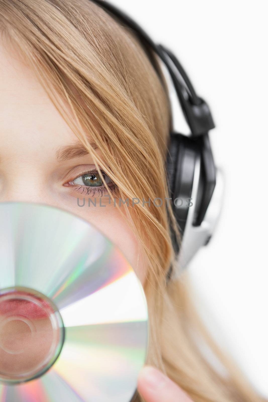 Close up of a blonde woman with a cd in front of her face against a white background