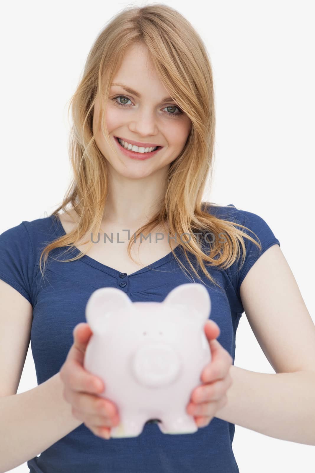 Blonde woman holding a piggy bank against a white background
