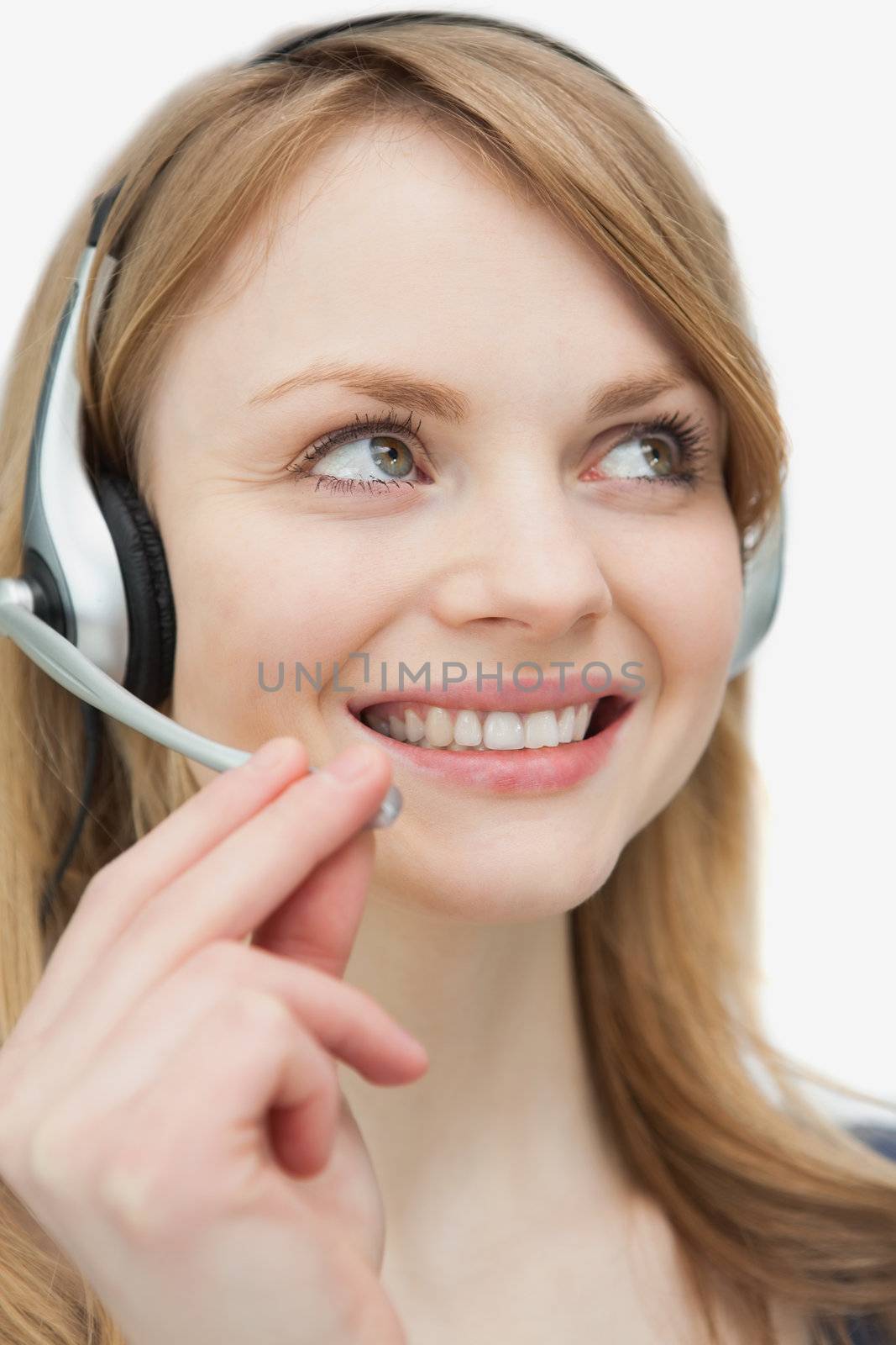 Close up of a woman with headset looking up against a white background