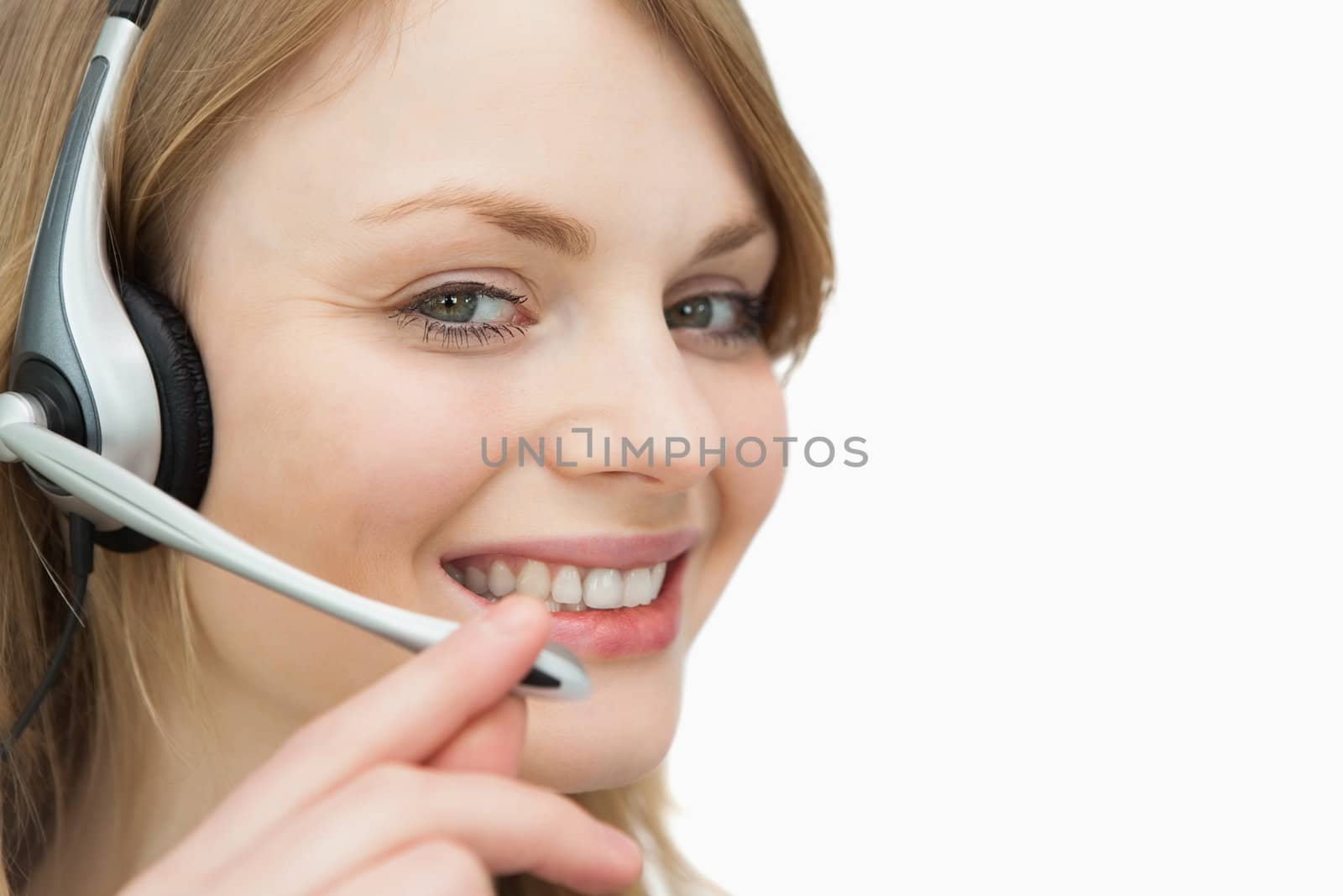 Woman with headset smiling against a white background