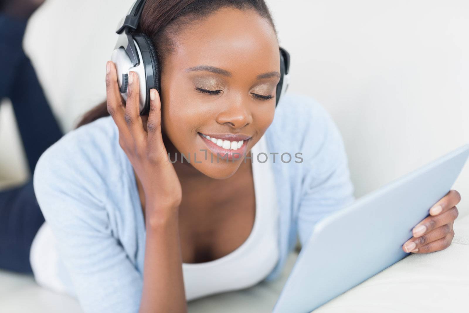 Black woman listening music with closed eyes in a living room