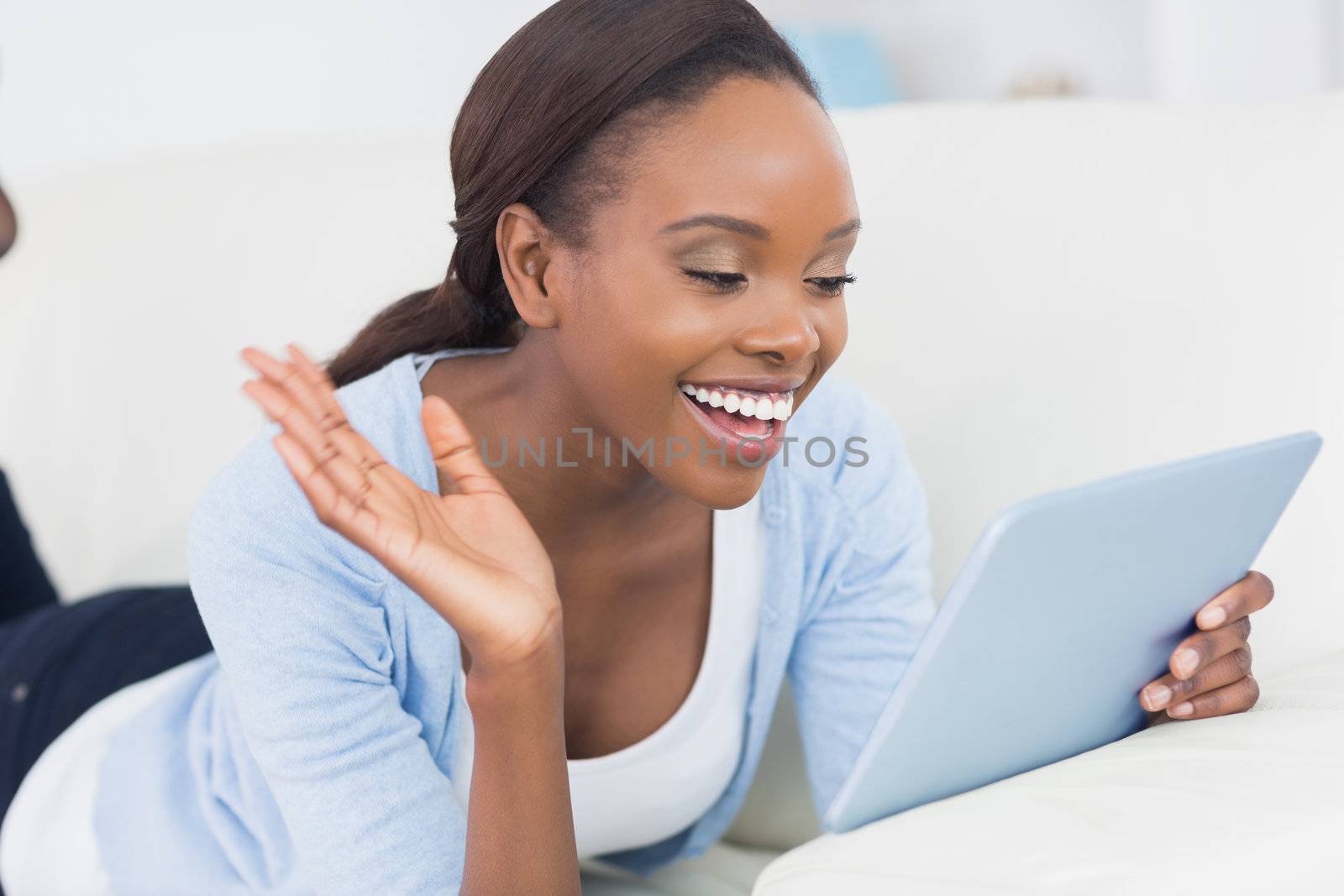 Black woman holding a tablet computer in a living room