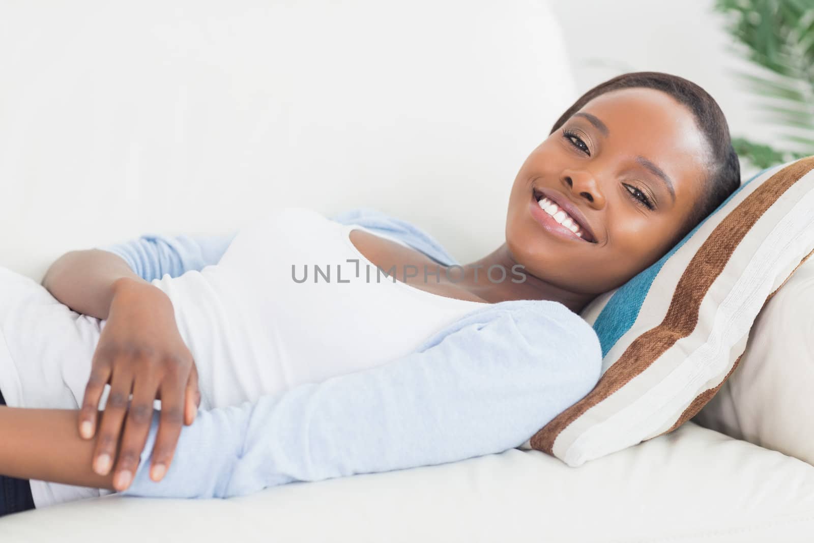 Black woman lying on back on a sofa in a living room