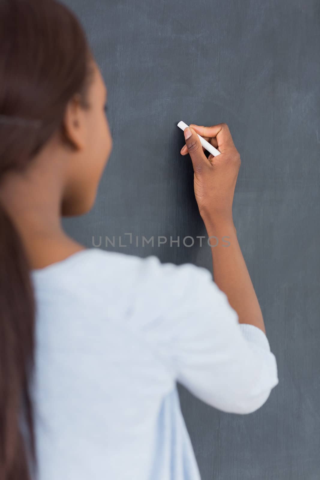 Focus on a black woman holding a chalk in classroom