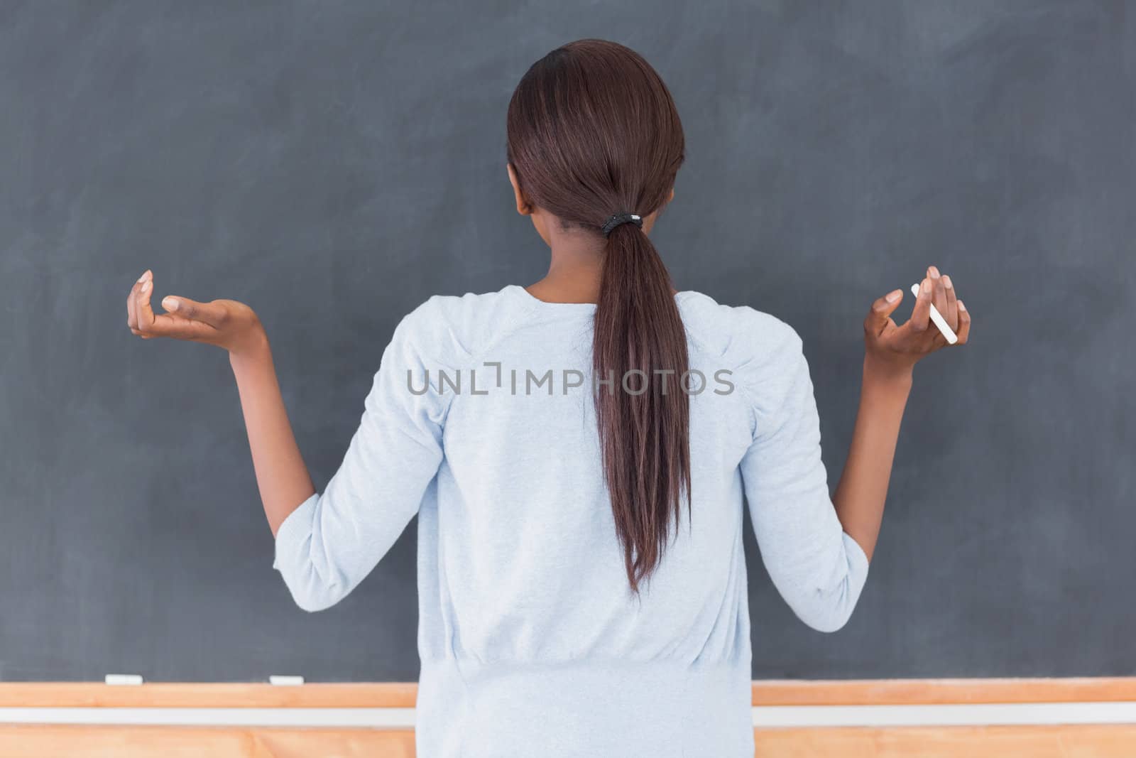 Black woman in front of a blackboard in a classroom