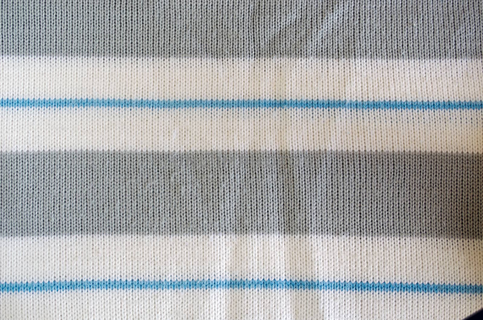 Knit woolen sweater texture. Fabric pattern blue white grey color background
