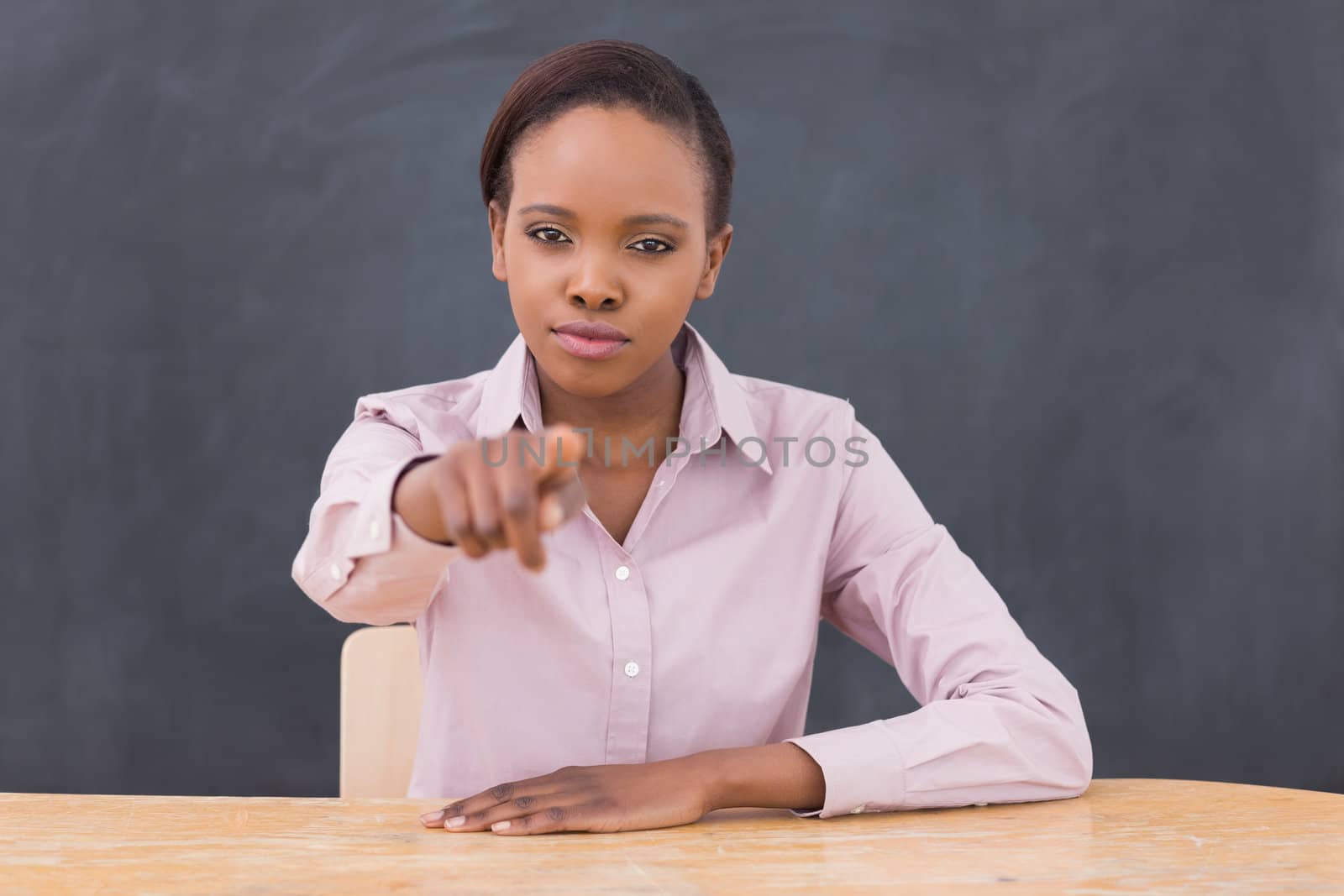 Serious teacher pointing of  finger in a classroom