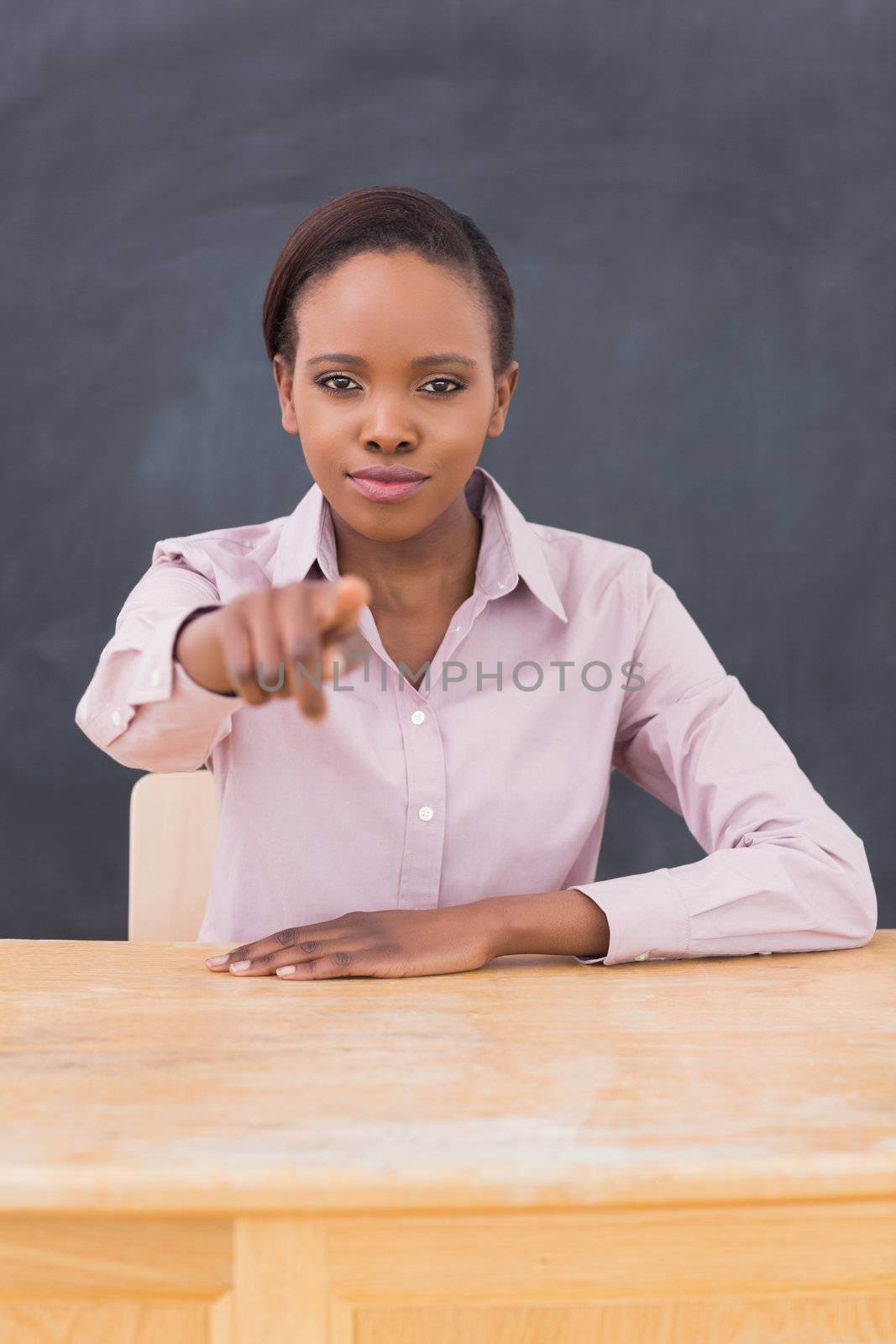 Strict teacher at her desk in a classroom
