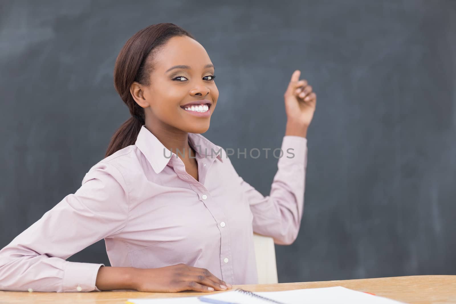 Black teacher showing the blackboard in a classroom