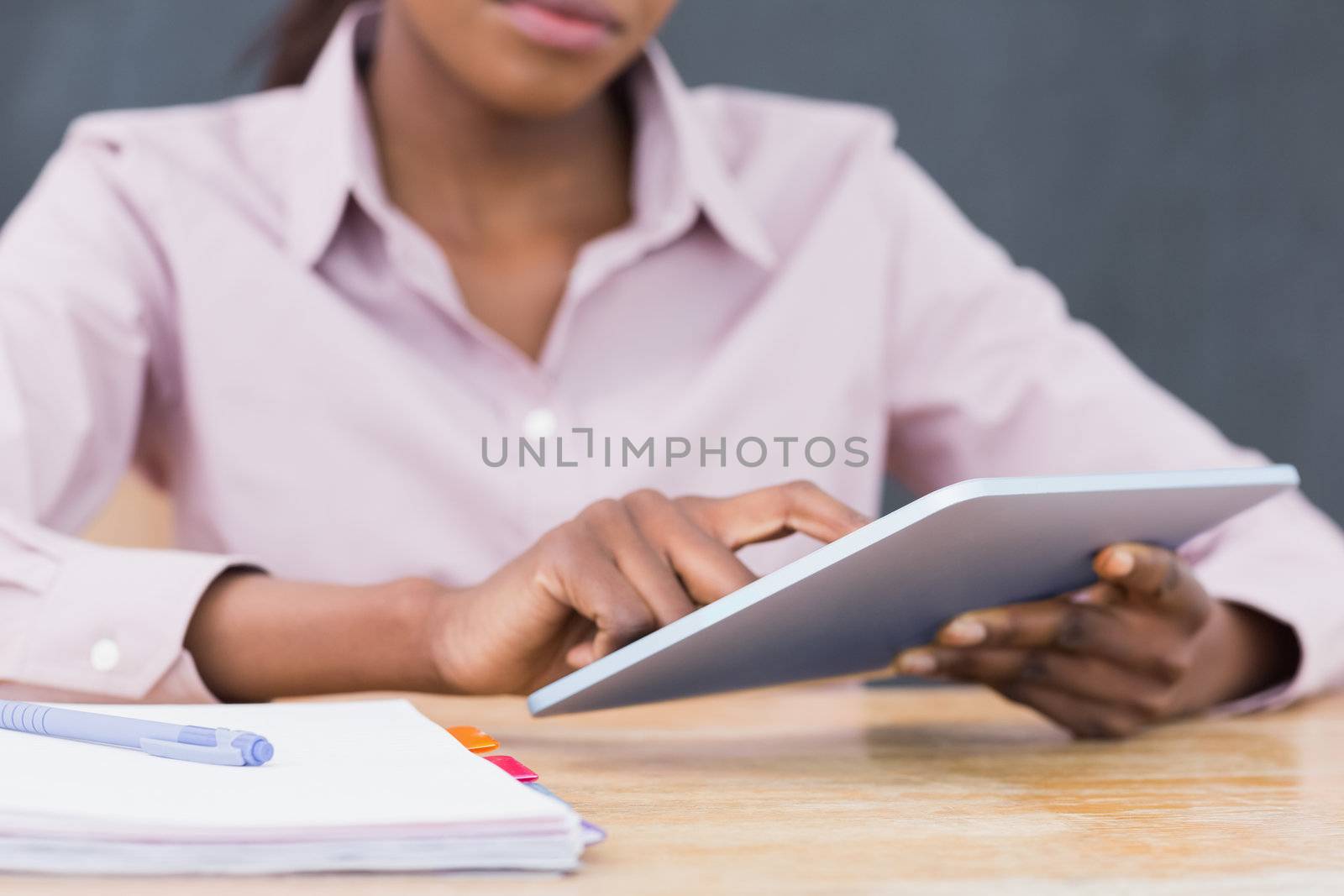 Close up of a teacher using a tablet computer in a classroom