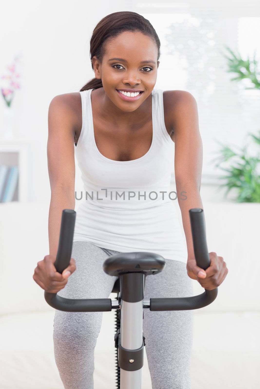 Black woman doing exercise bike in a living room