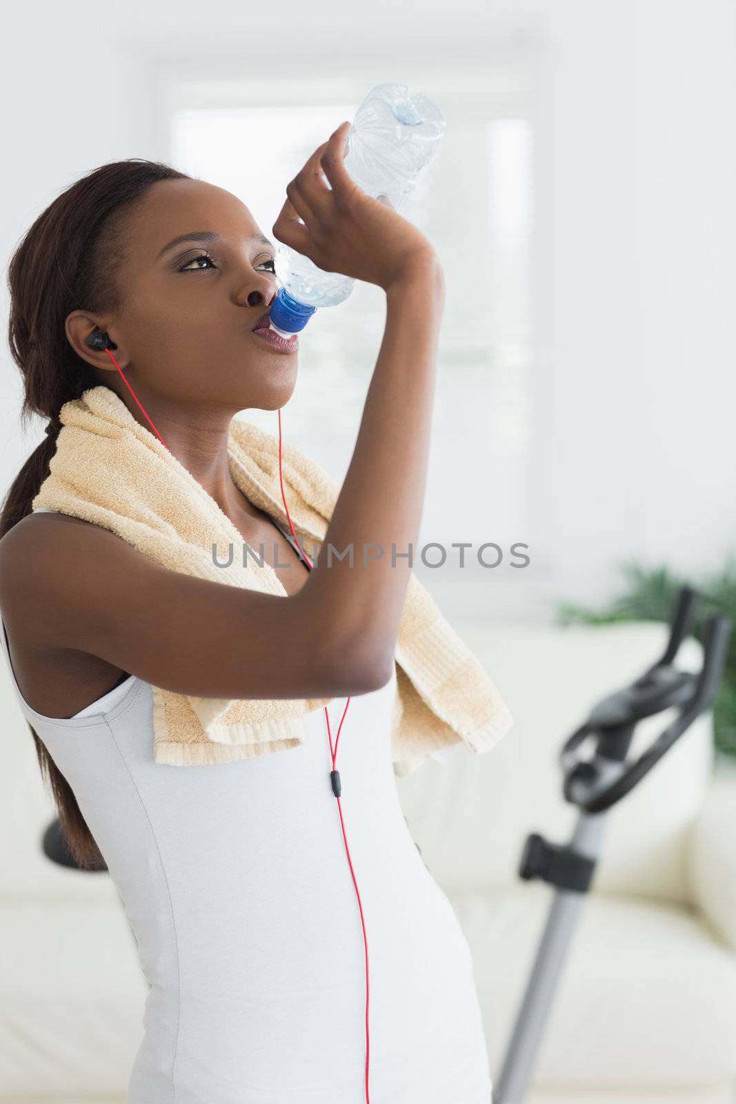 Black woman drinking water in a living room